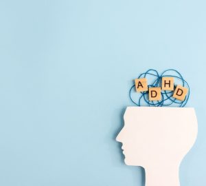 figura laterale di un volto e blocchi di legno con le lettere ADHD
