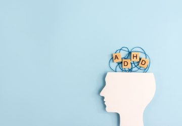 figura laterale di un volto e blocchi di legno con le lettere ADHD