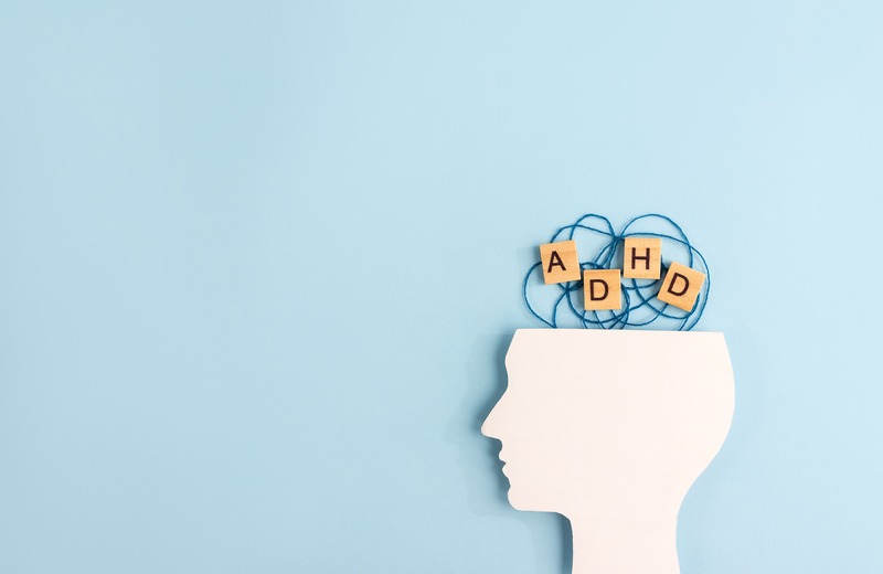 figura laterale di un volto e blocchi di legno con le lettere ADHD