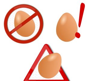intolleranza alle uova, disegno di uova con simboli di attenzione e divieto