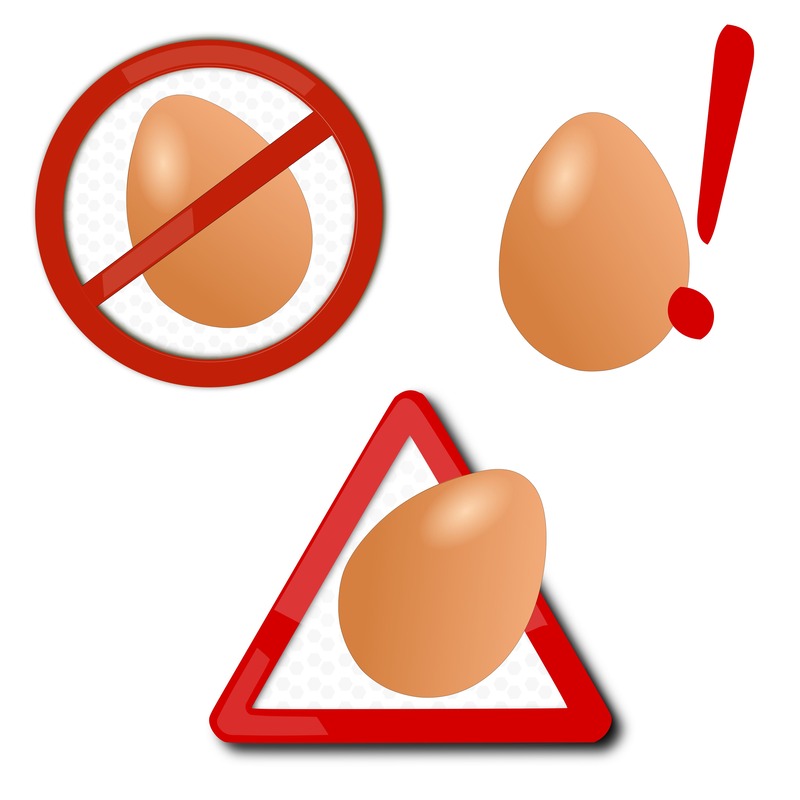intolleranza alle uova, disegno di uova con simboli di attenzione e divieto