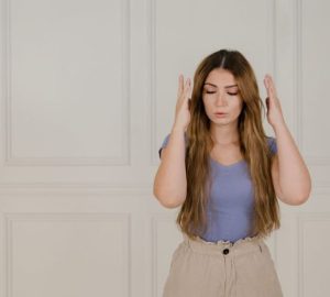 Quando un’otite si complica, possono comparire i segni della mastoidite: Giovane donna che segna con gli occhi chiusi…